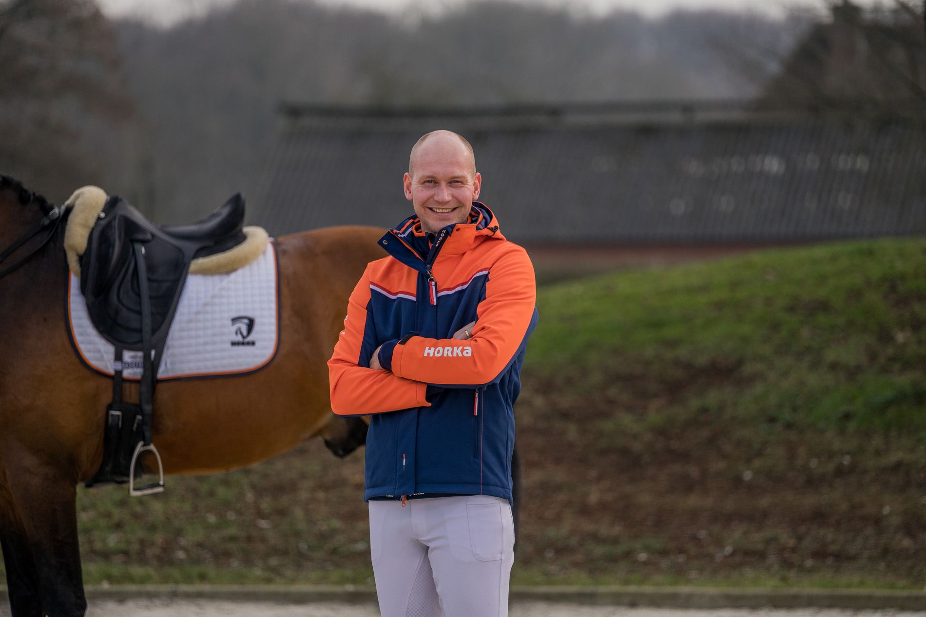 diederik van silfhout staat naast zijn paard in de nieuwe knhs teamkleding